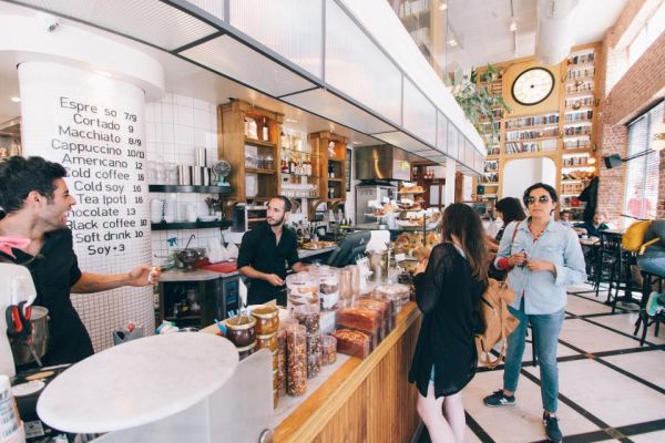 Mostrador de una cafetería con clientes pidiendo